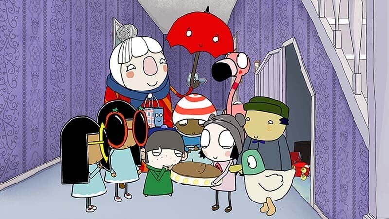 A group of animated characters, including Sarah & Duck, animals, and others, gather indoors under a staircase in a vividly patterned purple room for a cheerful birthday celebration.